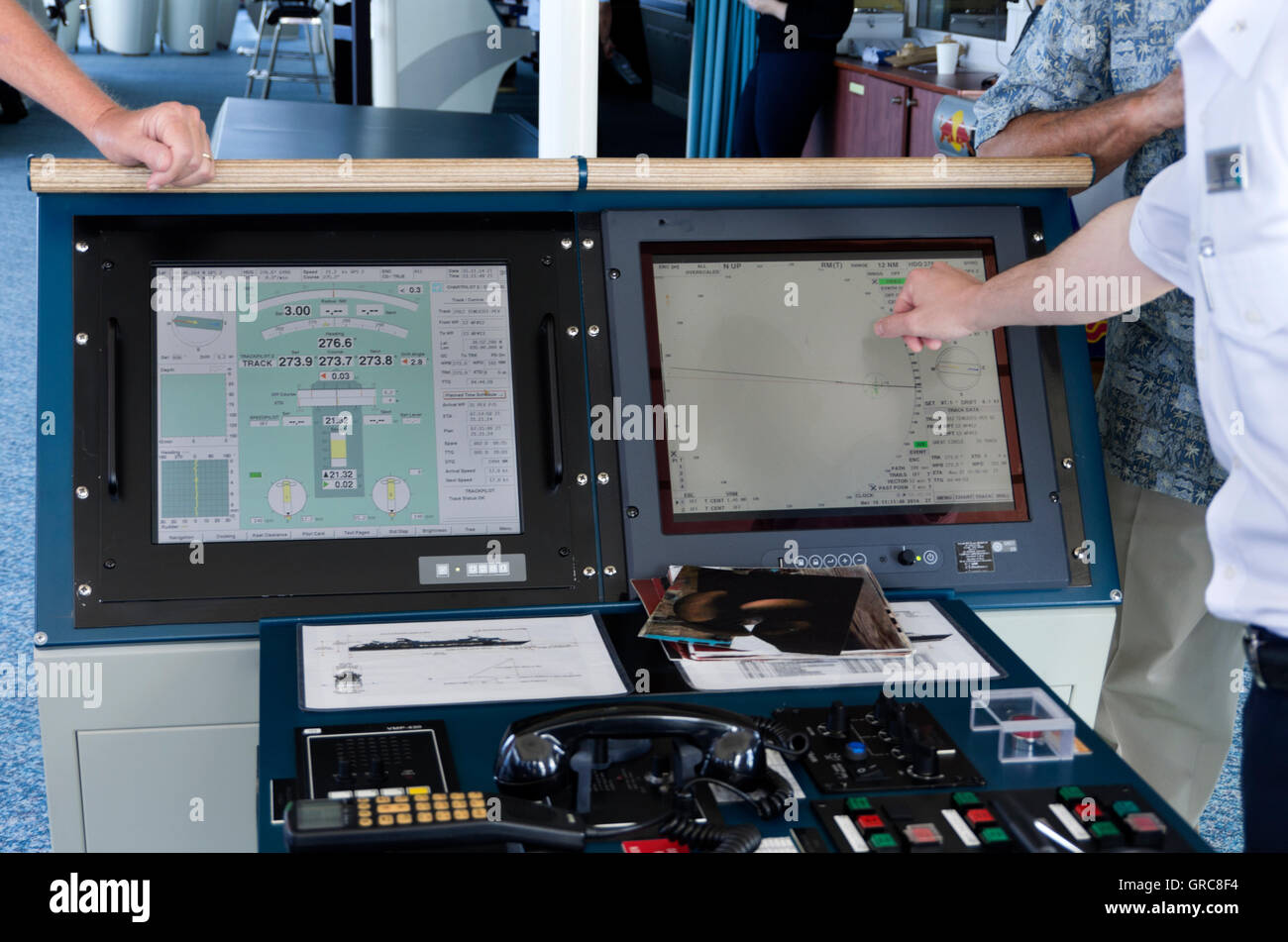 Officer explaning navigational aids to passengers on Cruise ship bridge. Stock Photo