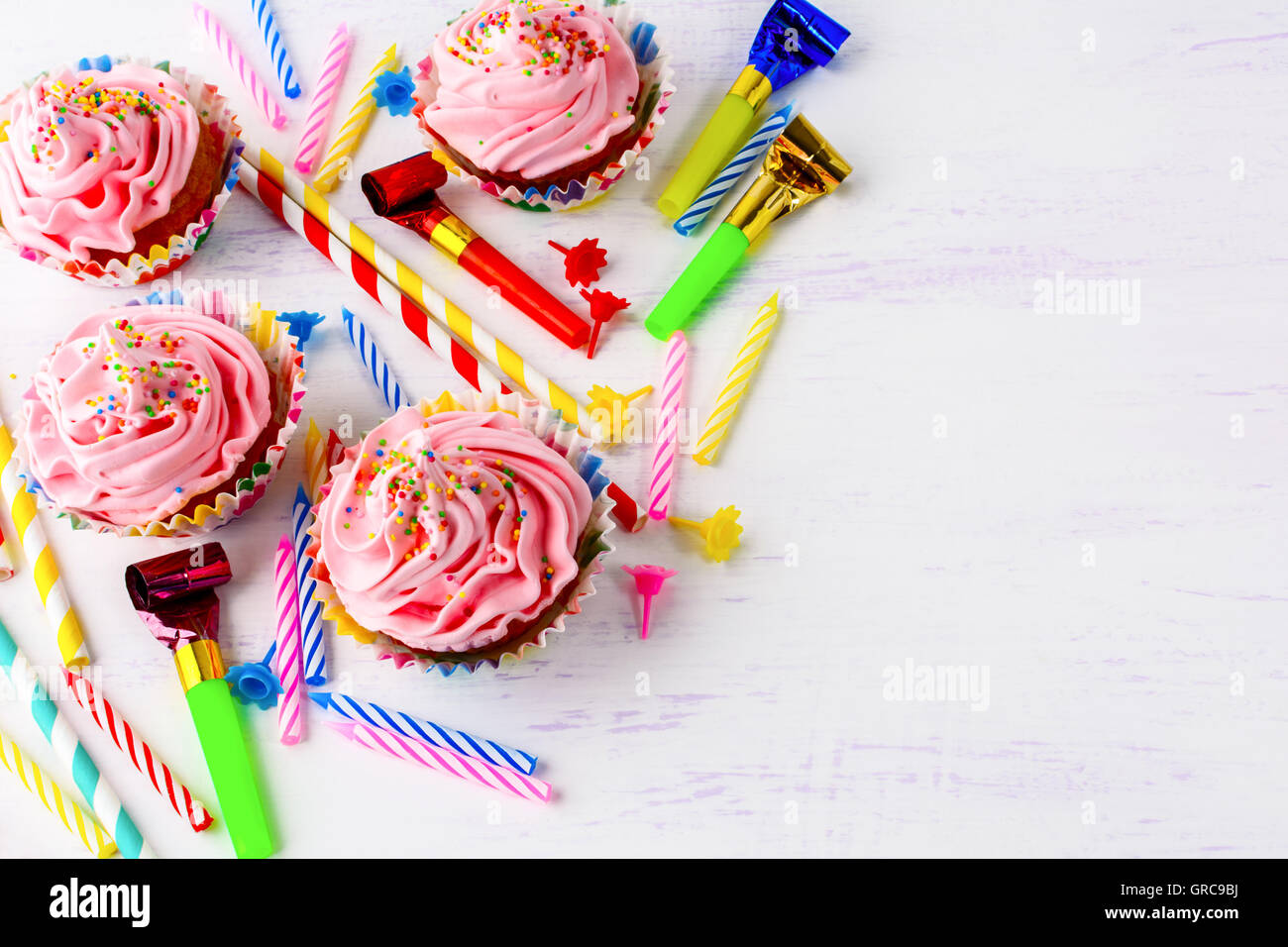 Birthday background with pink cupcakes and candles. Homemade cupcakes with whipped cream. Holiday party background. Copy space. Stock Photo