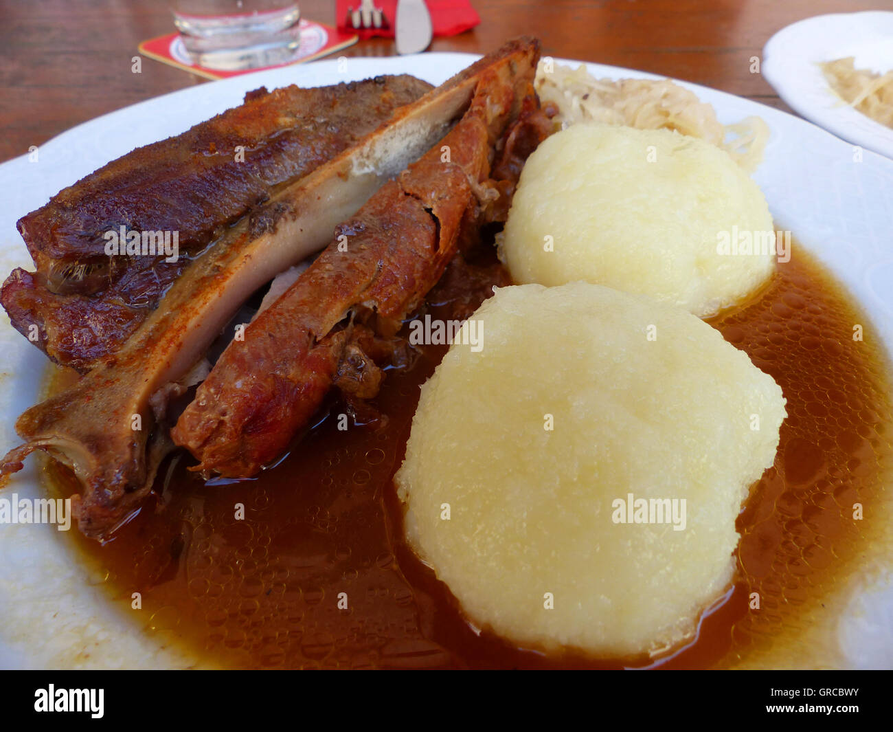 Franconian Schaeuferle With Crispy Fat Rind, Served With Potato Dumplings And Gravy Stock Photo