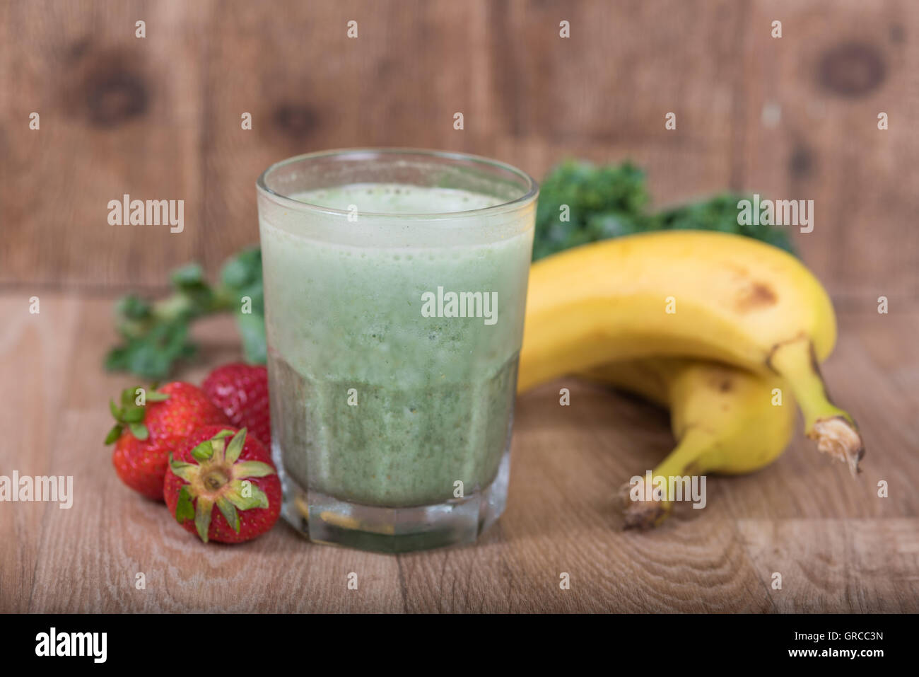 Green smoothie shake with bananas, strawberries and Kale Stock Photo