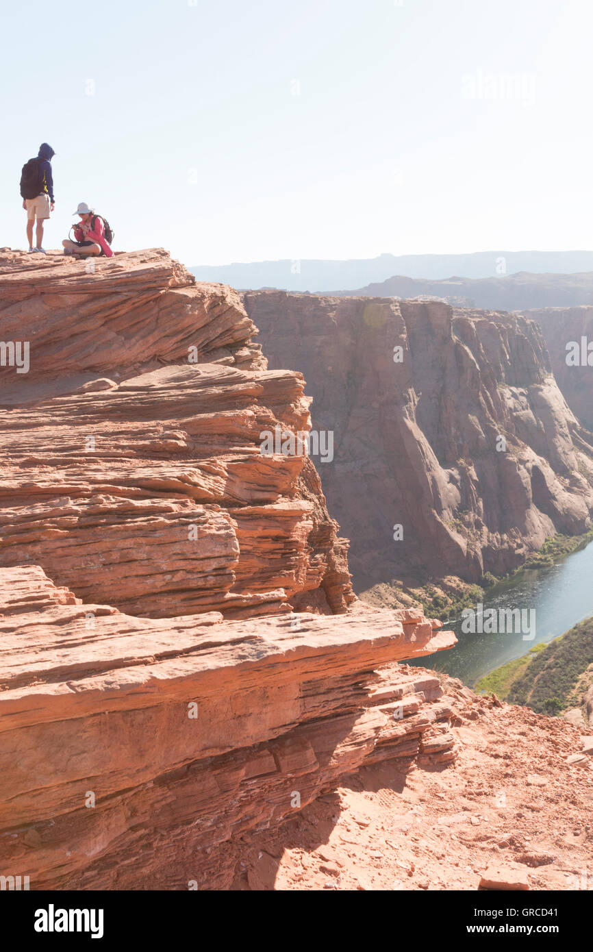 People on top of rock face at Horseshoe Bend looking over the Colorado River. Stock Photo