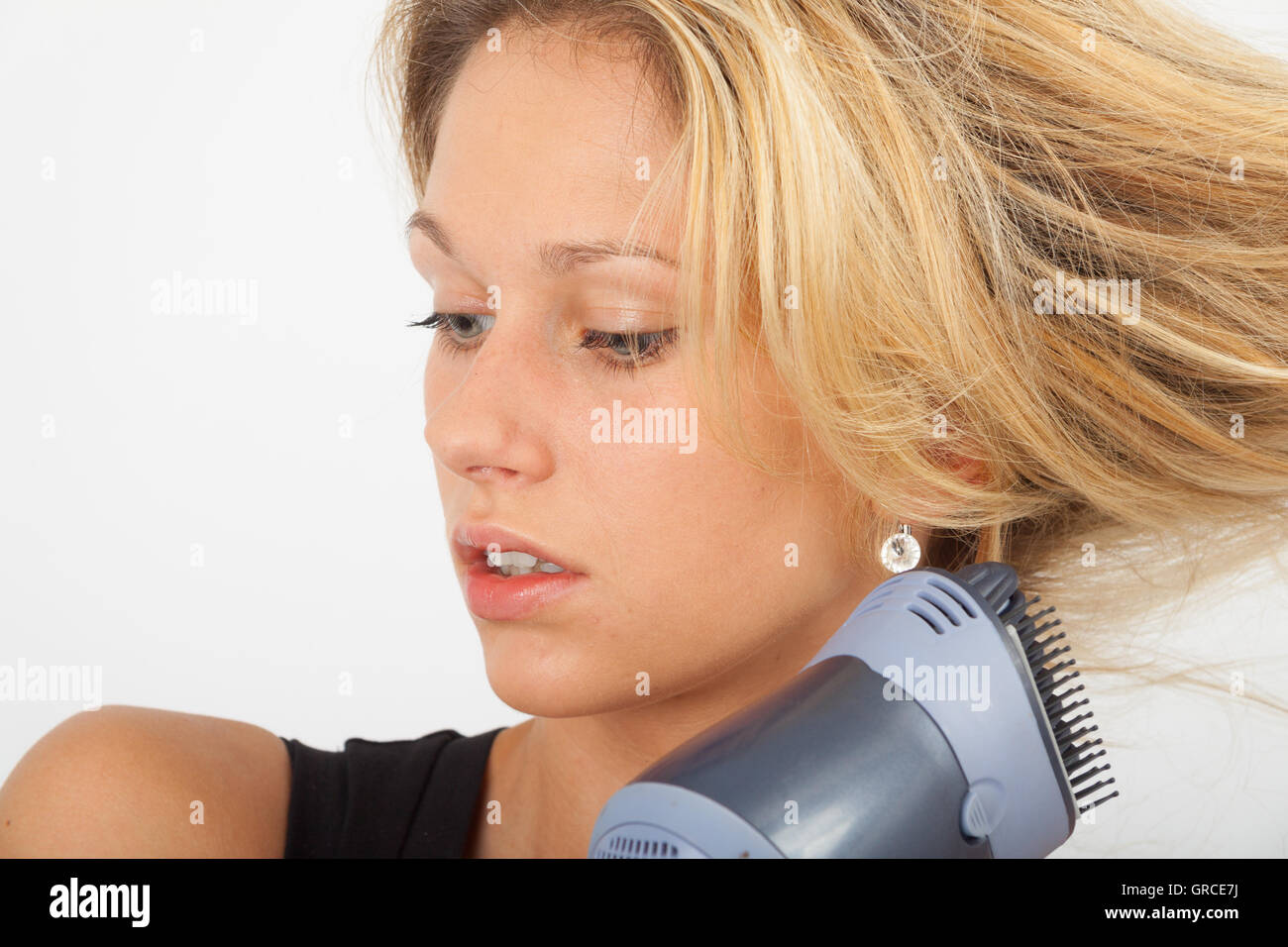 Young Blonde Blow Dries Her Hair On The Side Stock Photo - Alamy