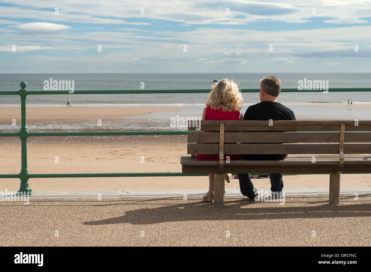 Couple sat looking out to the North sea at Seaburn, Sunderland, north east England, UK Stock Photo