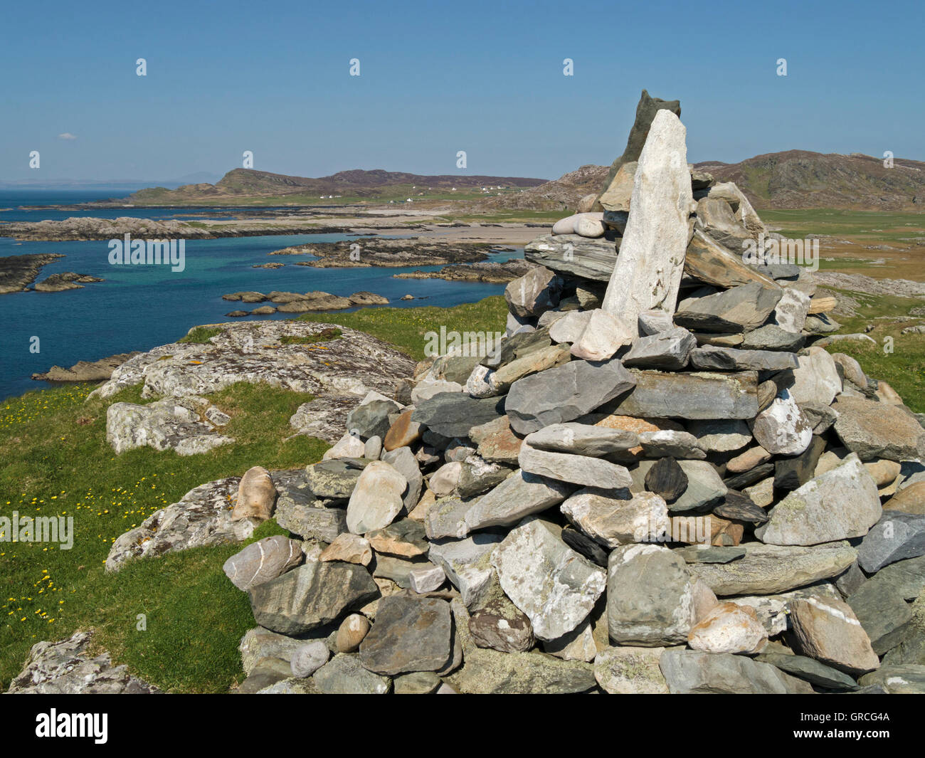 Summit cairn, Dun Ghallain Hill Fort, Ardskenish, with west coast of Colonsay beyond, Isle of Colonsay, Scotland, UK. Stock Photo