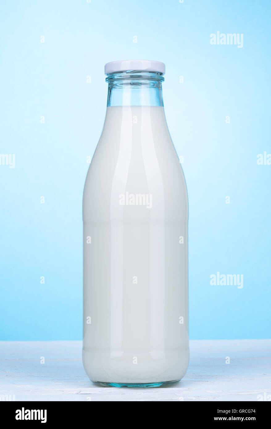 Bottle of milk on white wooden board and light blue background Stock Photo