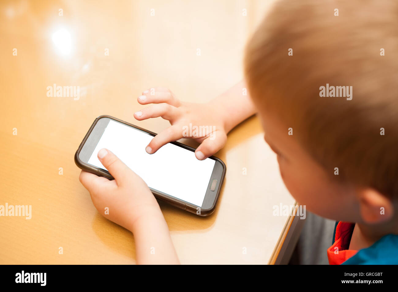 Young boy plays with a smart phone Stock Photo