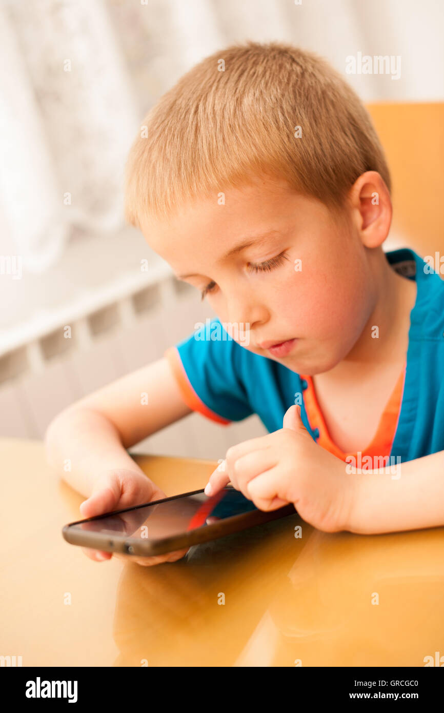 Young boy plays with a smart phone Stock Photo
