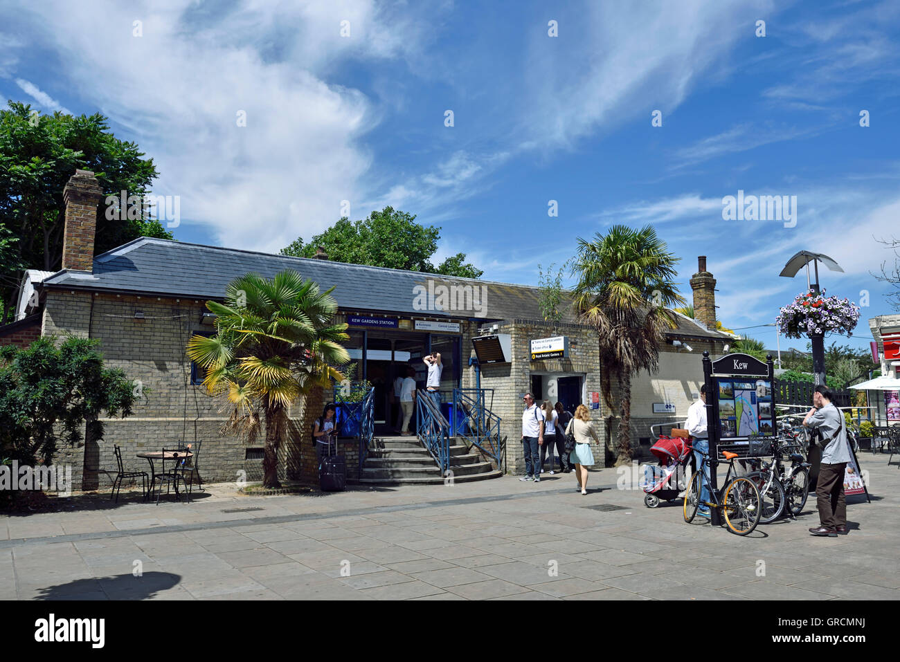 People outside Kew Gardens Station on a sunny day, North Road, London