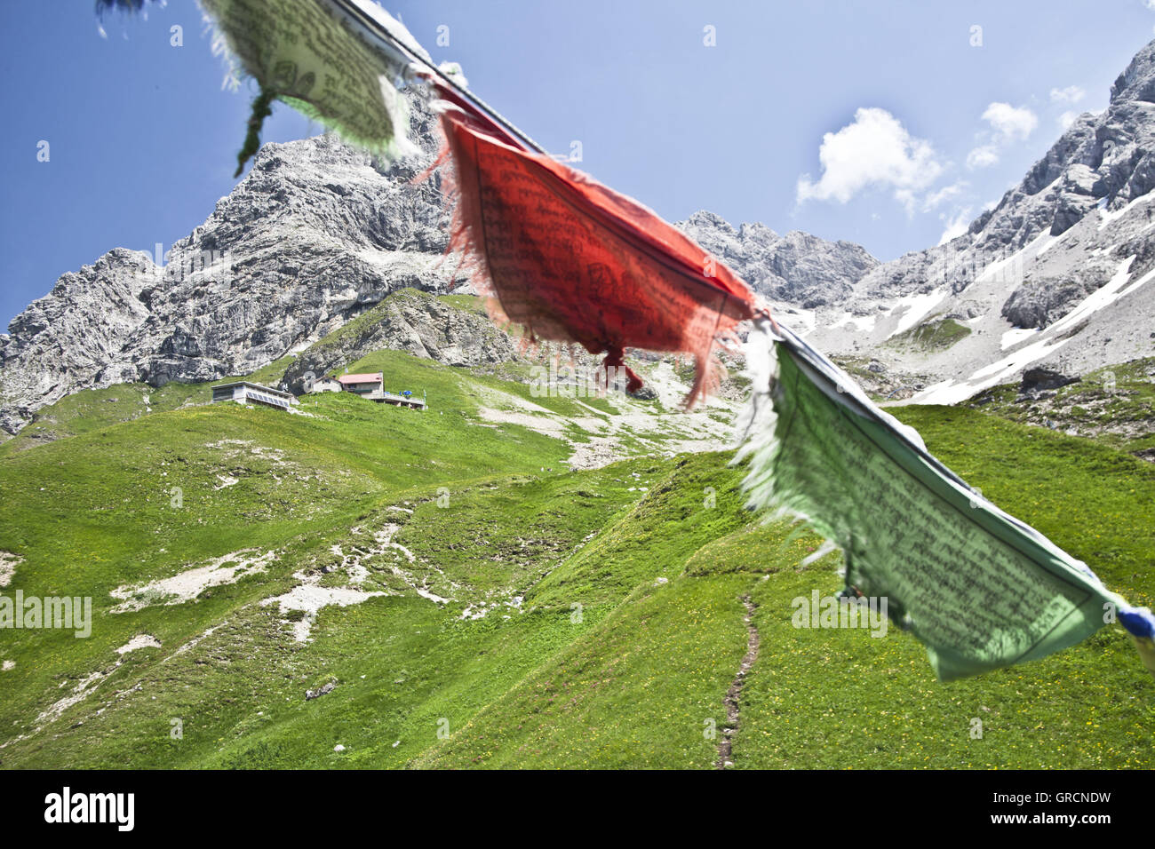 Tibetian Flag Infront Mountains With And Waltenberger Haus Stock Photo