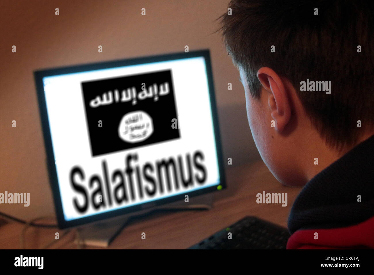 Teenager Sitting In Front Of A Computer With Sign Of Is Islamic State Salafism Stock Photo