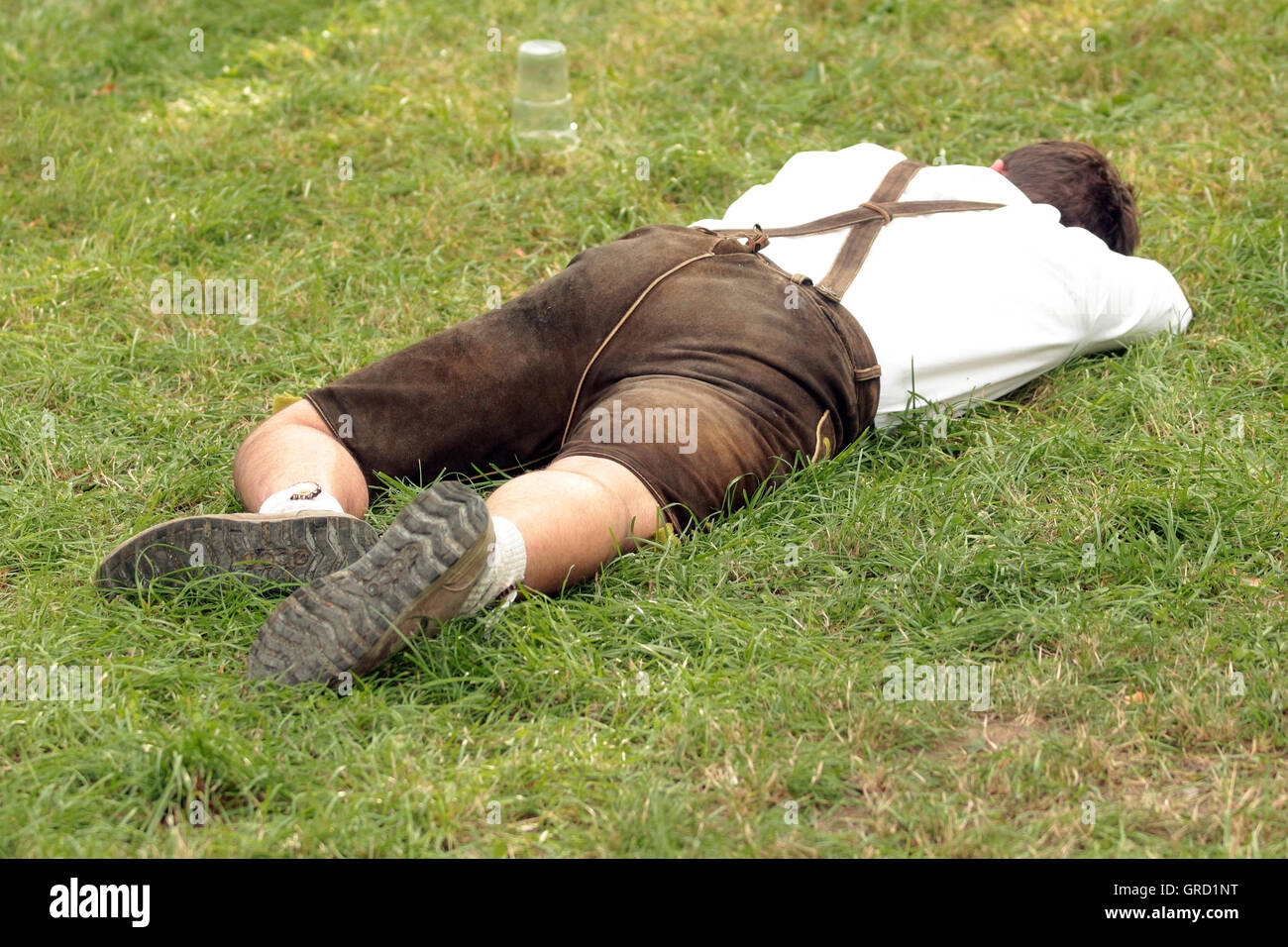 Drunk Man In Lederhose Sleeping At Oktoberfest Stock Photo