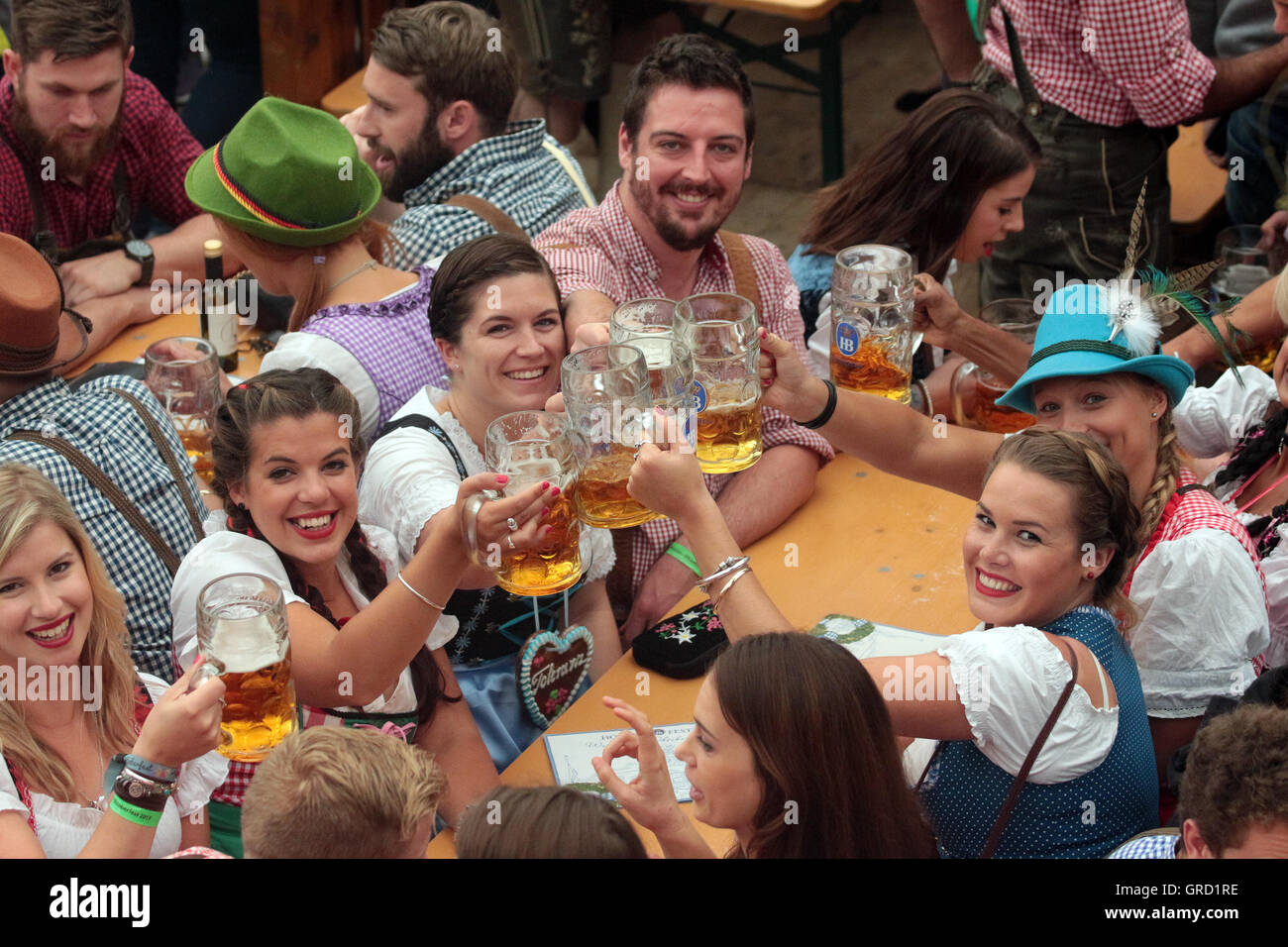 Visitors Of Munich Oktoberfest Toast Each Other With Glasses Of Beer Stock Photo Alamy