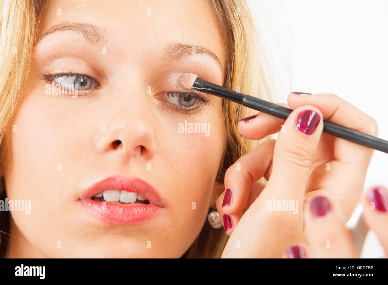 Young Woman Putting On Eyeshadow With A Spatula Stock Photo