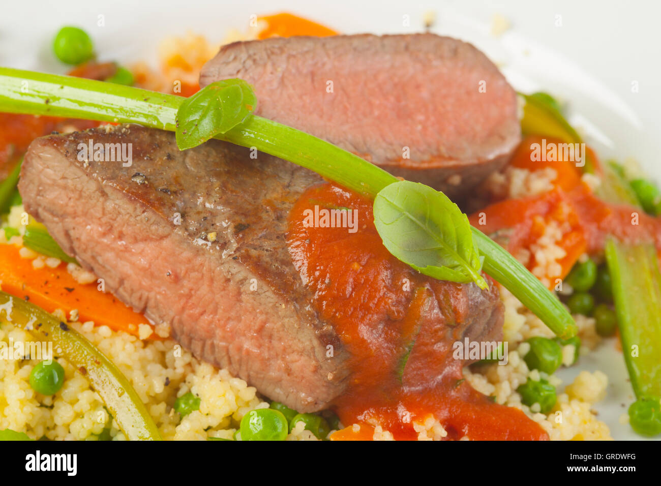 Roast Lamb On Rice With Carrots And Peas Stock Photo