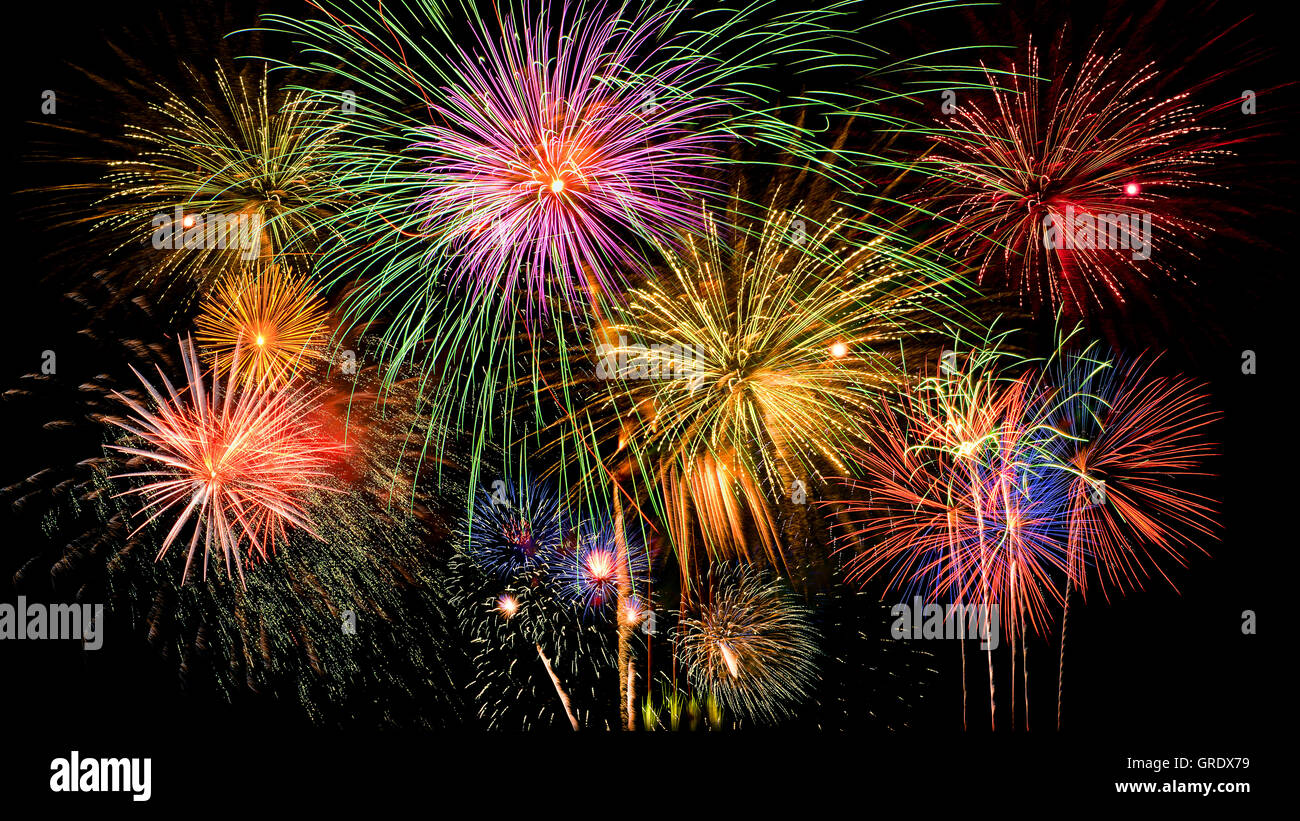 Colorful firework celebration on dark night sky background. Beautiful fireworks show on clear night sky. Stock Photo