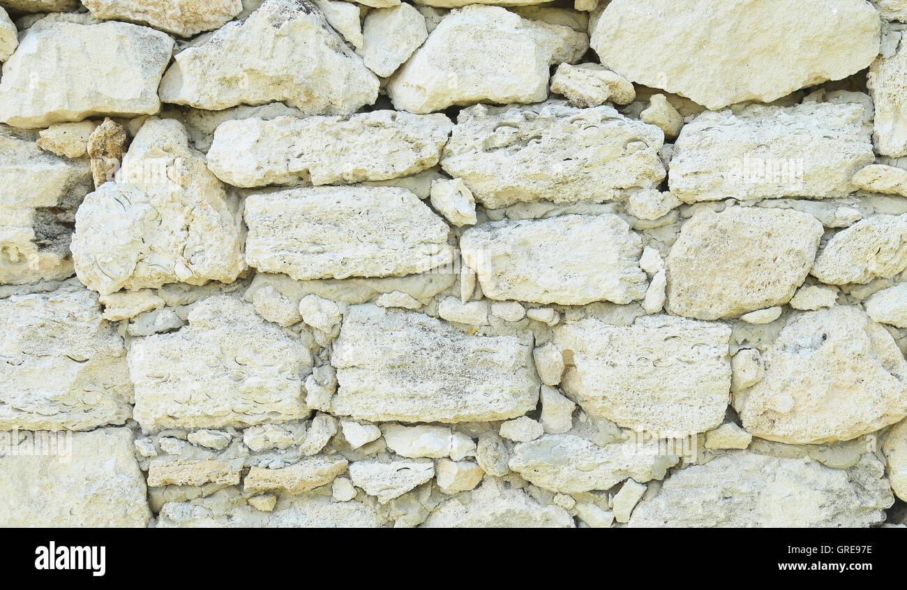 Old weathered stone wall for background. Close-up. Stock Photo