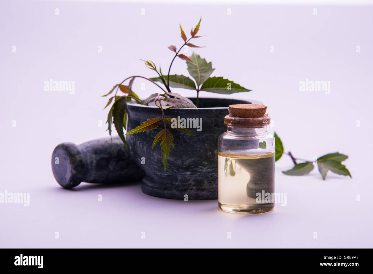 Ayurvedic Herbs Neem with Oil in bottle with mortar Stock Photo
