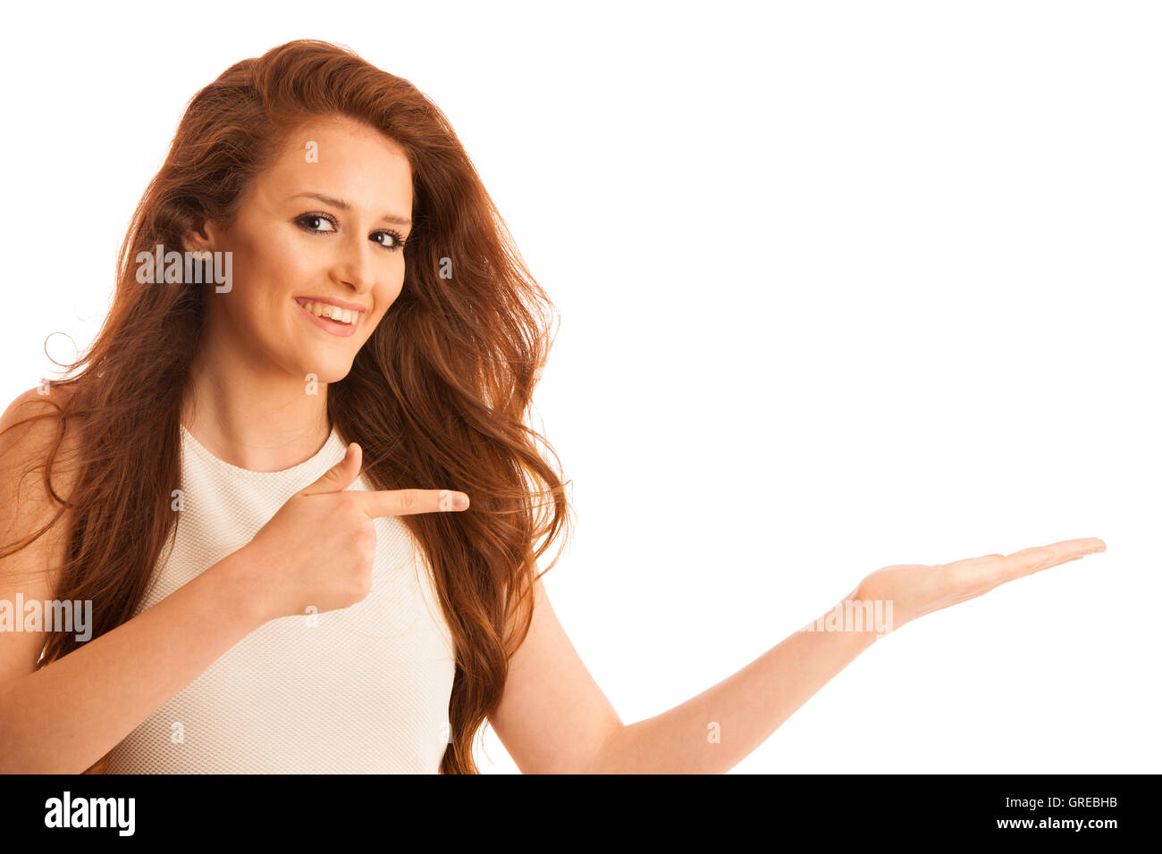 Business woman holds hand and points to copy space as she would hold a product for commercial isolated over white background Stock Photo