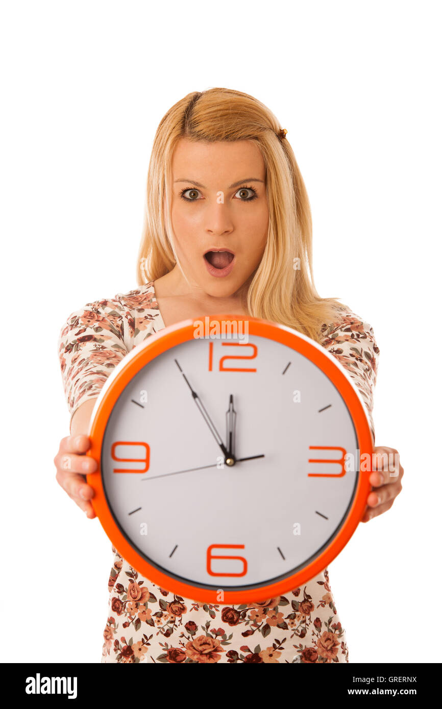 Cute blond woman with a big orange clock gesturing being late isolated over white Stock Photo