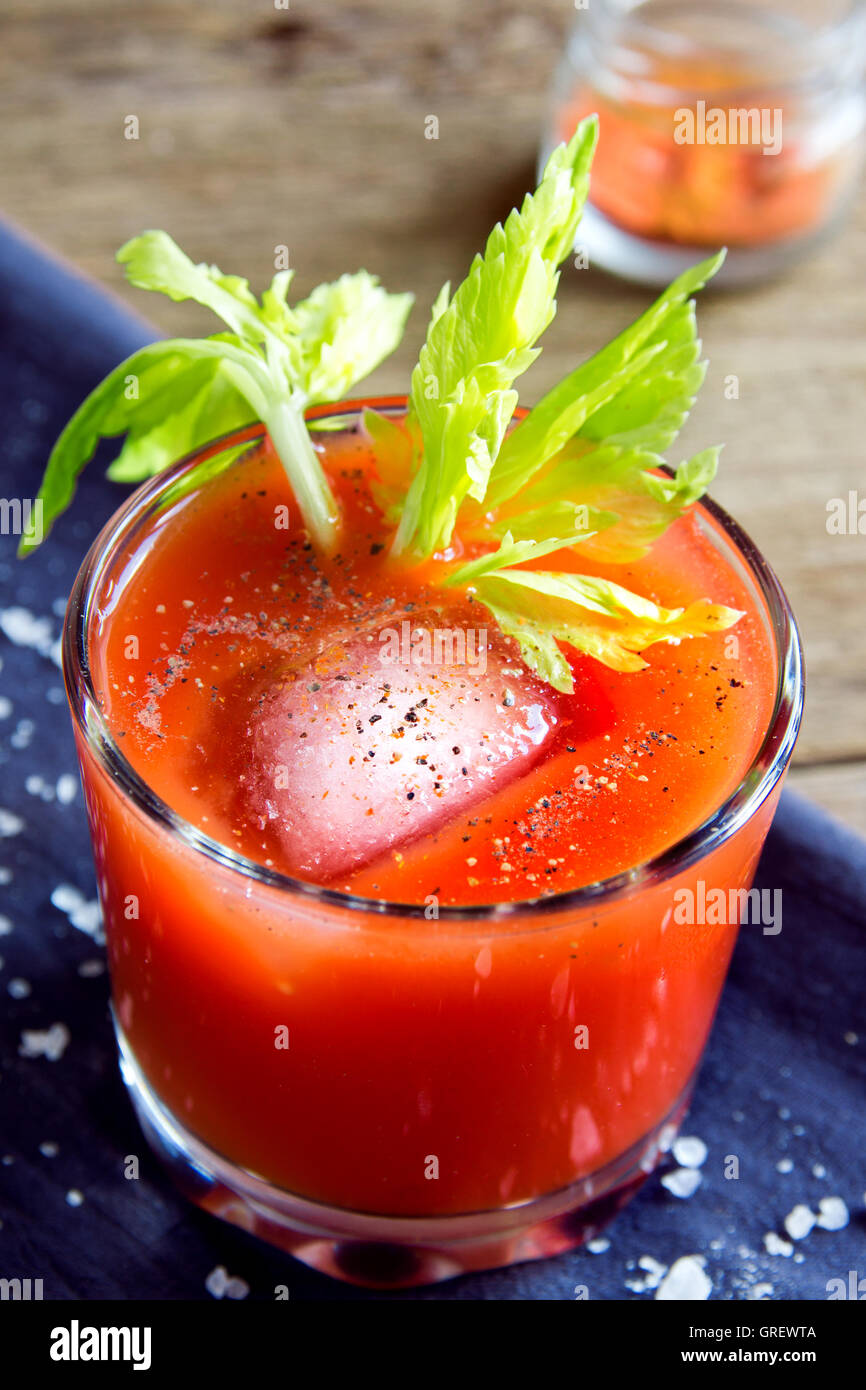 Tomato juice with celery, spices, salt and ice in portion glasses Stock Photo