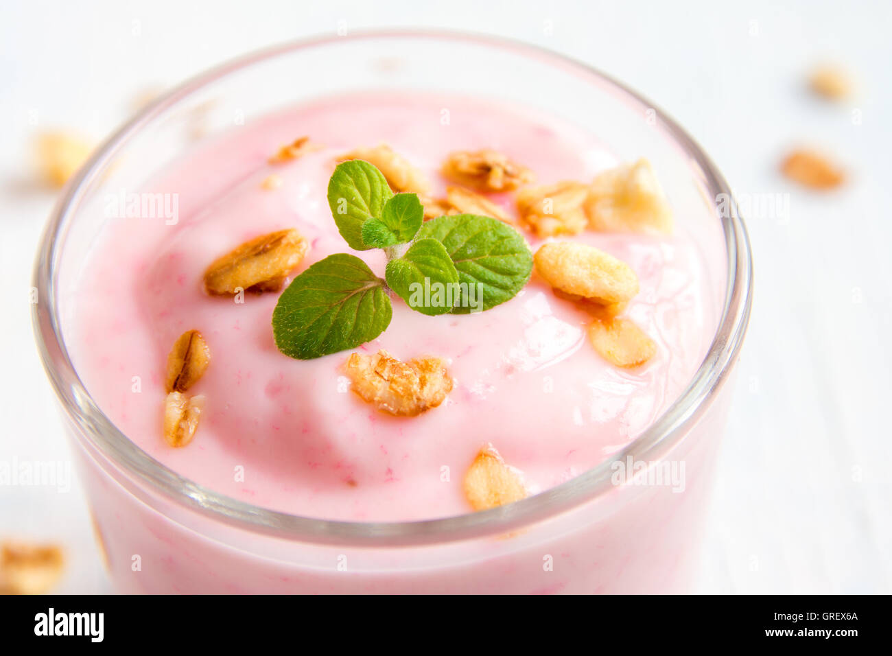 Homemade organic strawberry yogurt with granola and mint in portion glasses close up Stock Photo