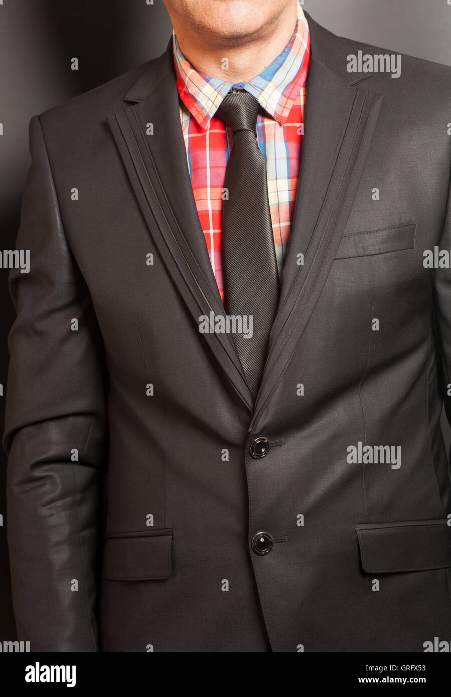 Man in black suit and black tie on a black background Stock Photo - Alamy