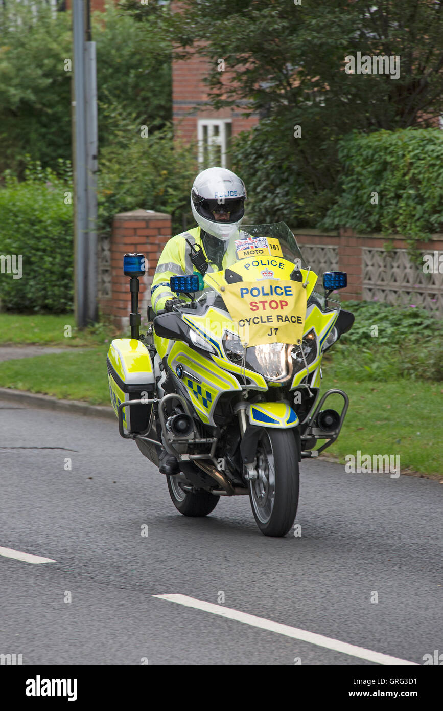 A Police Motorcyclist Escorting the Tour of Britain Cycle Race Through Alsager in Cheshire England United Kingdom UK Stock Photo