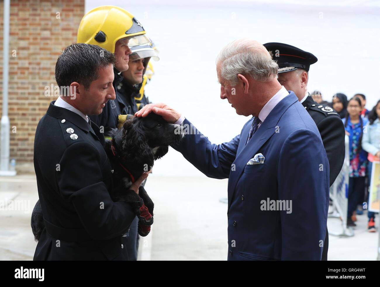 The Prince of Wales Fire Inspector Paul Osborne with fire investigation dog Sherlock during his visit to Shadwell Fire Station where he officially reopened the rebuilt fire station in celebration of the London Fire Brigade's 150th anniversary year. Stock Photo