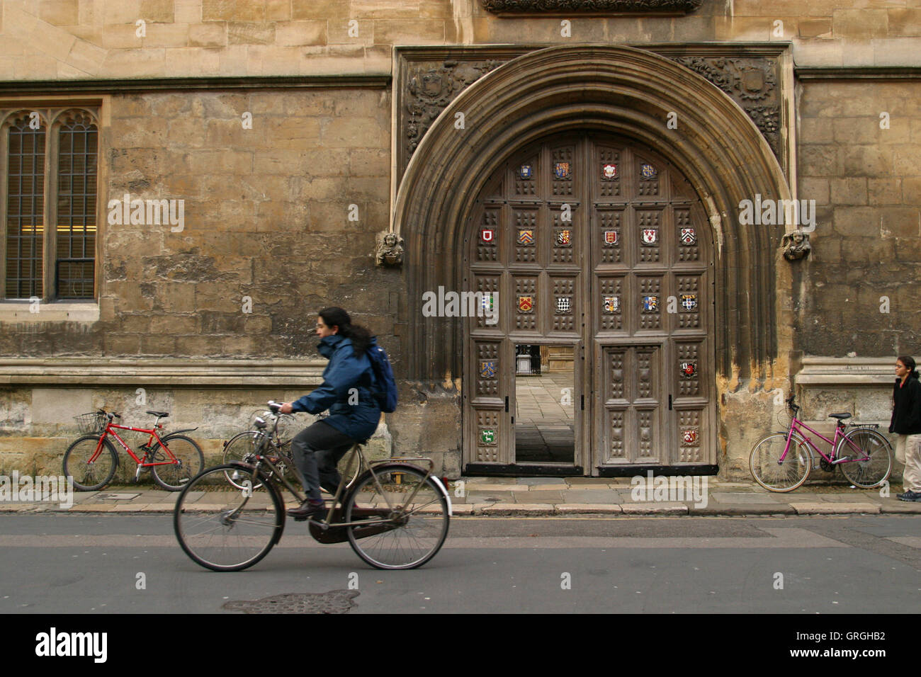 Oxford, England, a cyclist on Catte Street passes the Great Gate of the 1602 Bodleian Library. Cycling is the most popular form transport in Oxford Stock Photo