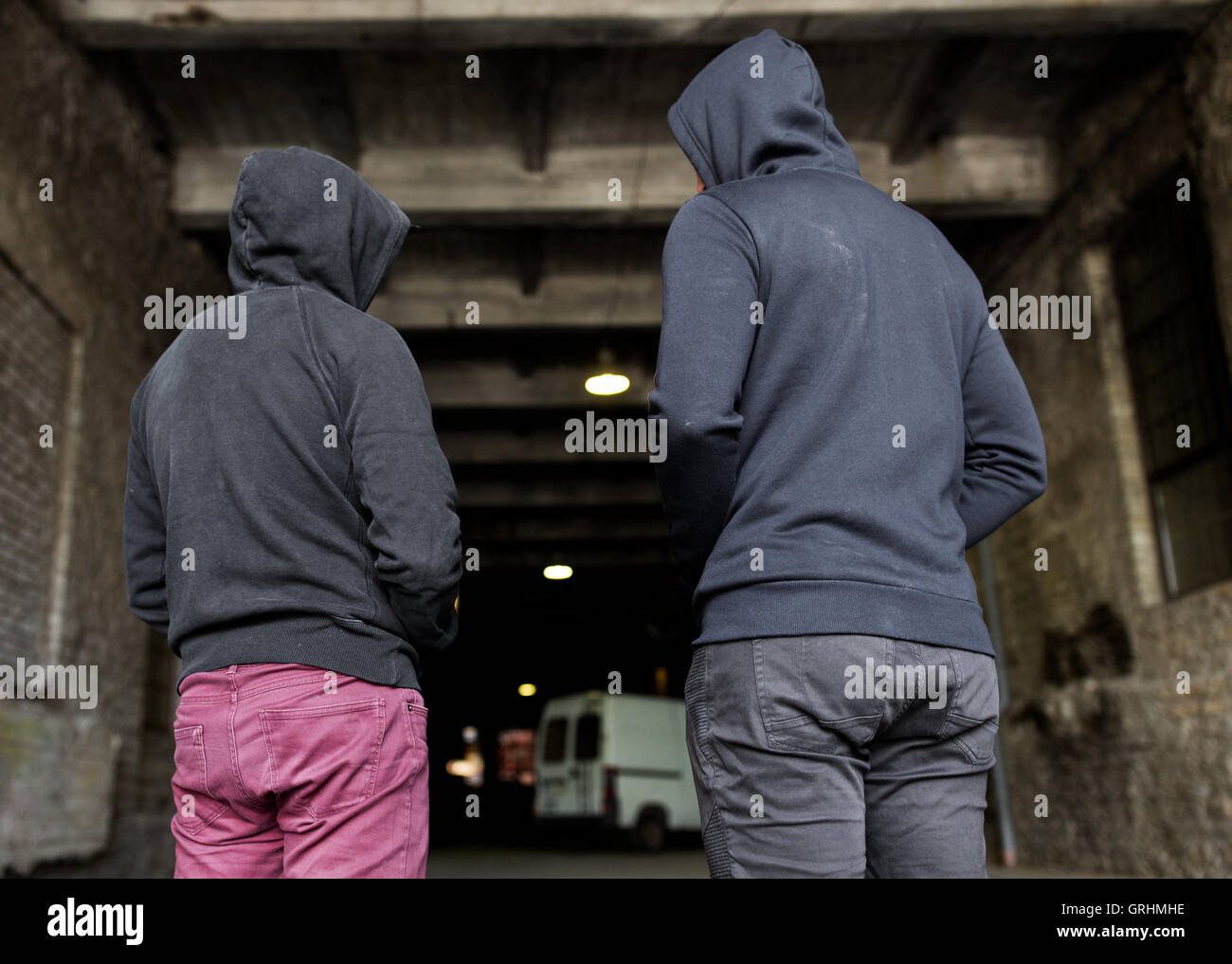 addict men or criminals in hoodies on street Stock Photo