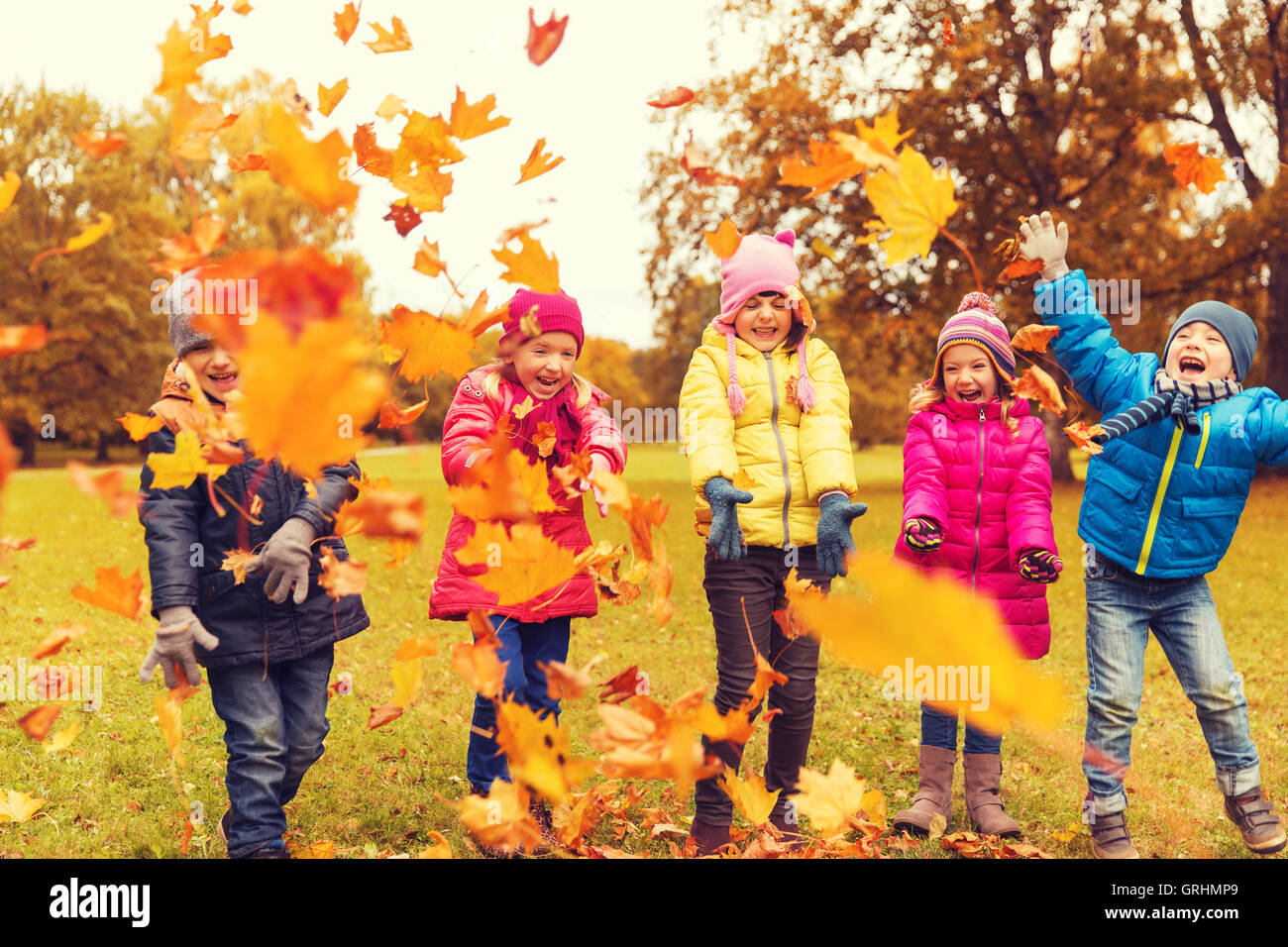 happy children playing with autumn leaves in park Stock Photo - Alamy