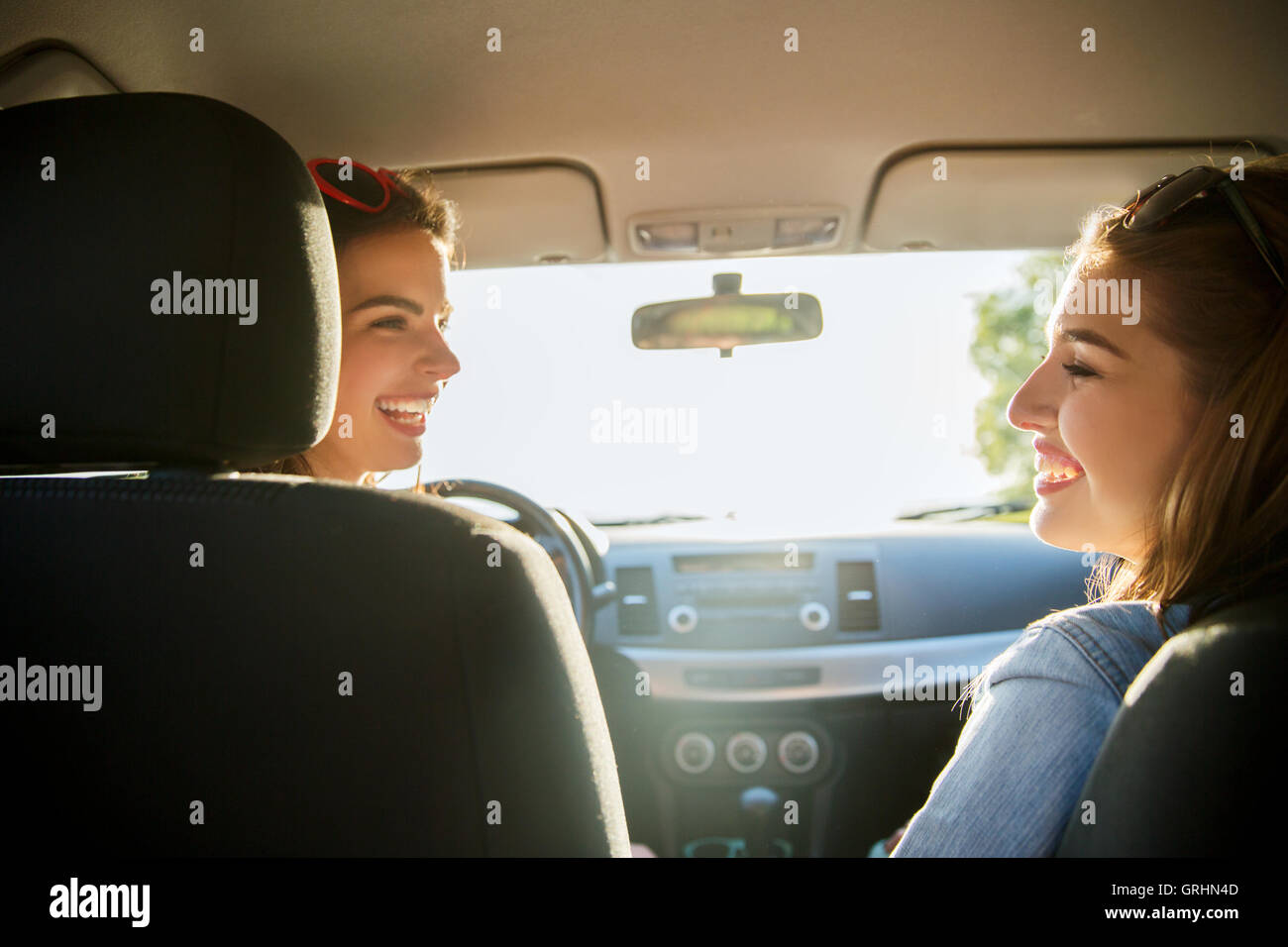 happy teenage girls or women in car at seaside Stock Photo - Alamy