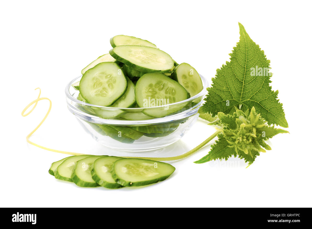 Sliced cucumber in glass bowl vith leaves on white Stock Photo