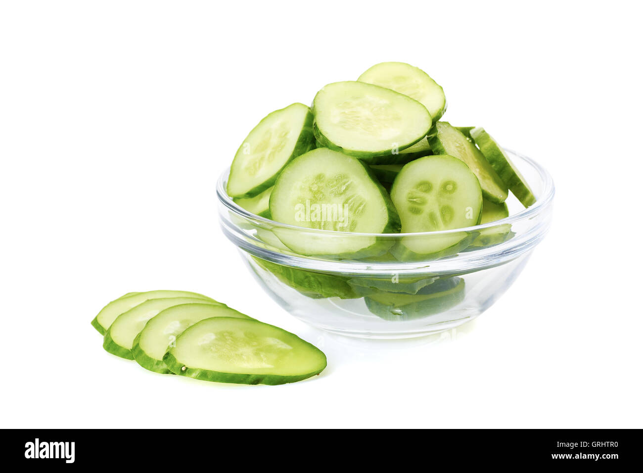 Sliced cucumber in glass bowl on white Stock Photo