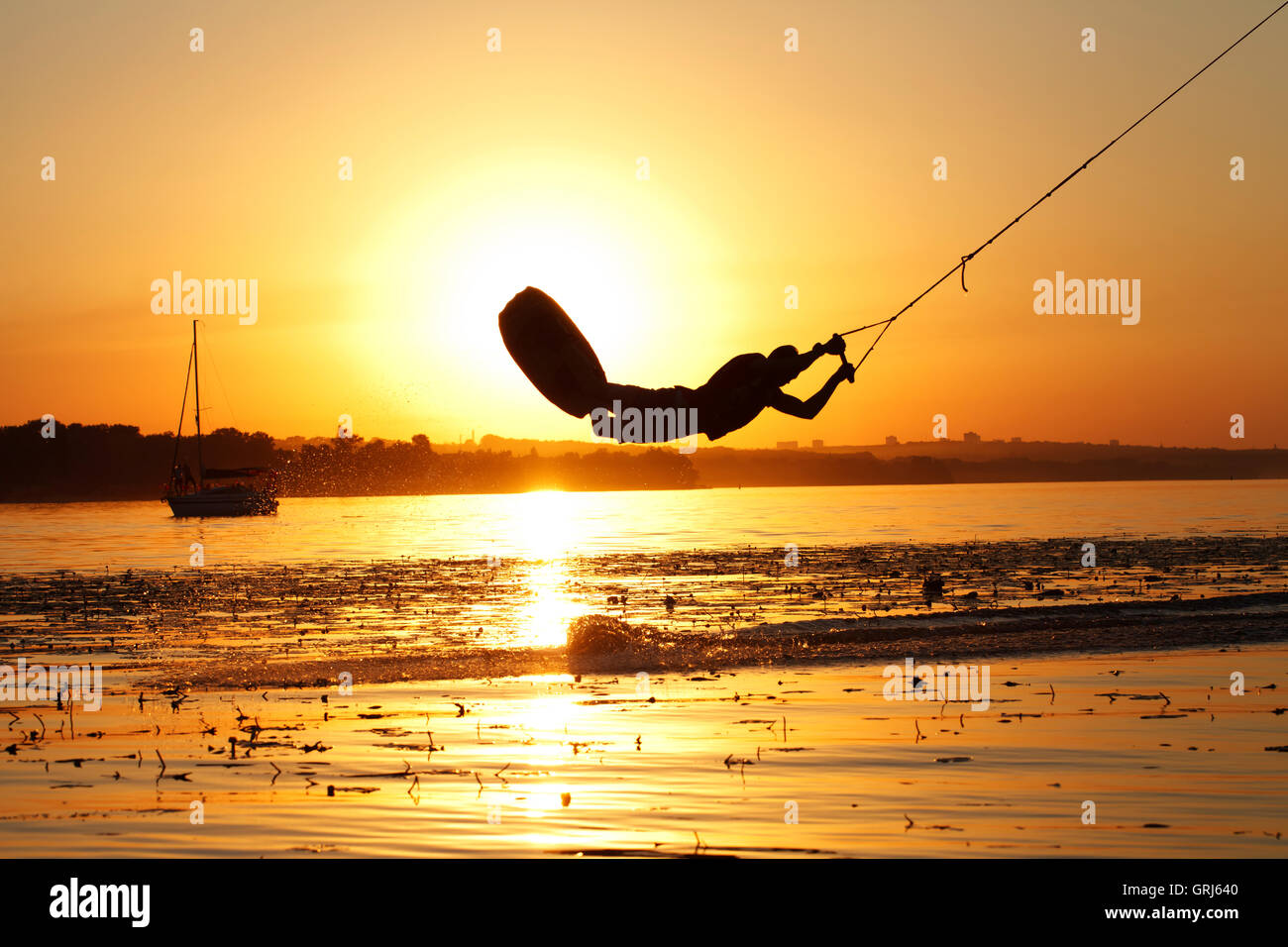 a wakeboard, athlete silhouette on sunset background Stock Photo