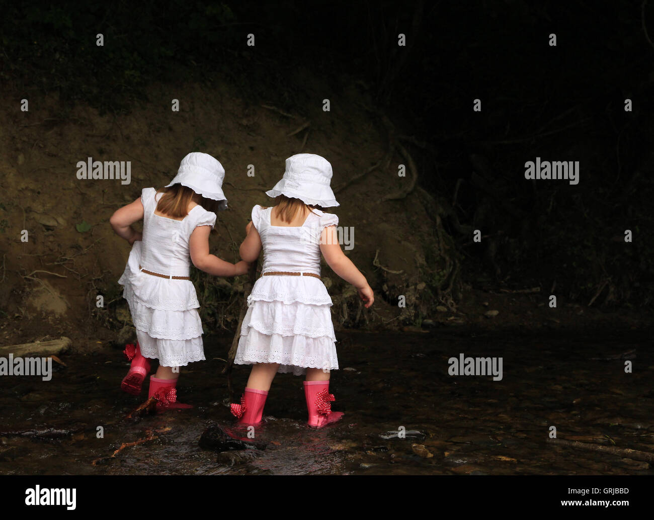 Twins walking in the river Stock Photo