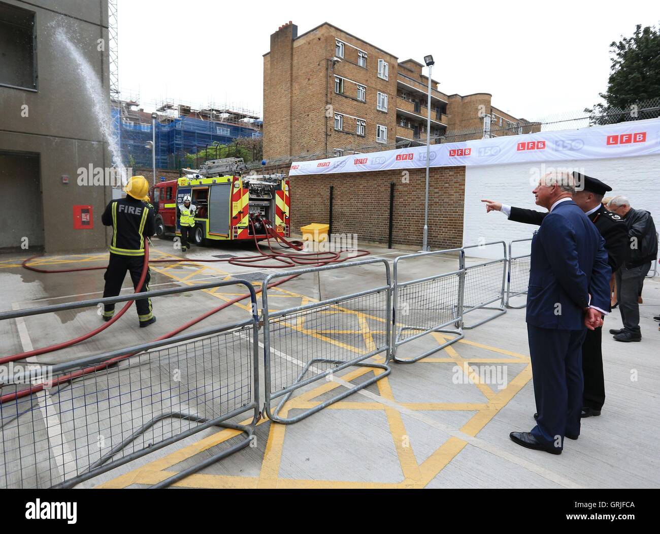 The Prince of Wales watches a fire fighting demonstration during his visit to Shadwell Fire Station where he officially reopened the rebuilt fire station in celebration of the London Fire Brigade's 150th anniversary year. Stock Photo