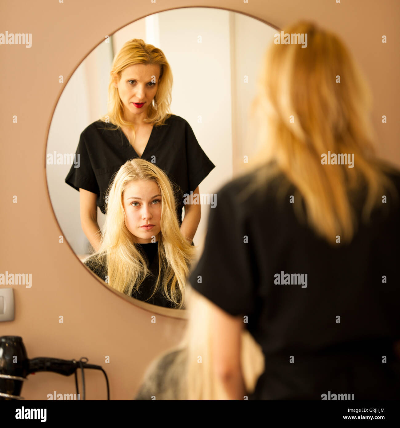 In hairdresser salon - hair stylist consulting a customer before doing her hairstyle Stock Photo
