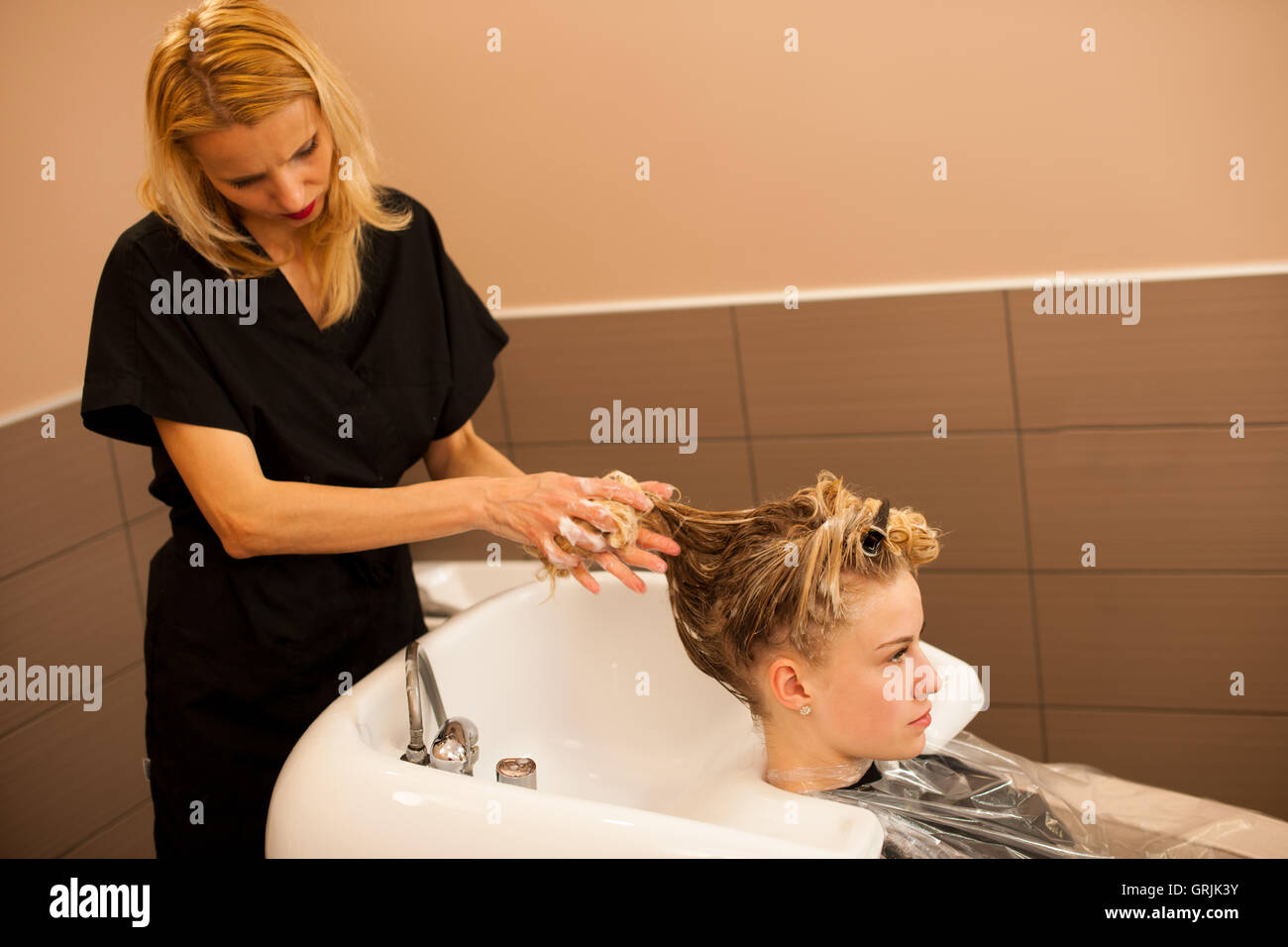 Hair Stylist At Work Hairdresser Washing Hair To The Customer