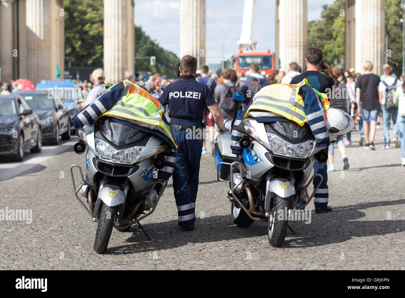 Policeman officer standing next to police motorbikes at Pariser Platz in Berlin, Germany. Stock Photo