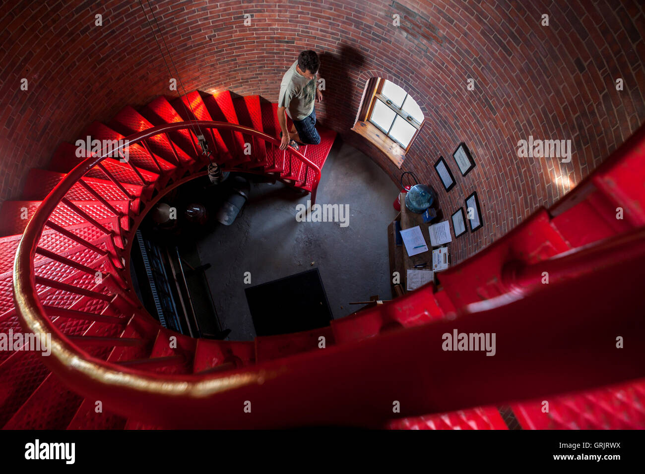 A man walks down the spiral staircase in Race Point Lighthouse in Provincetown, MA. Stock Photo