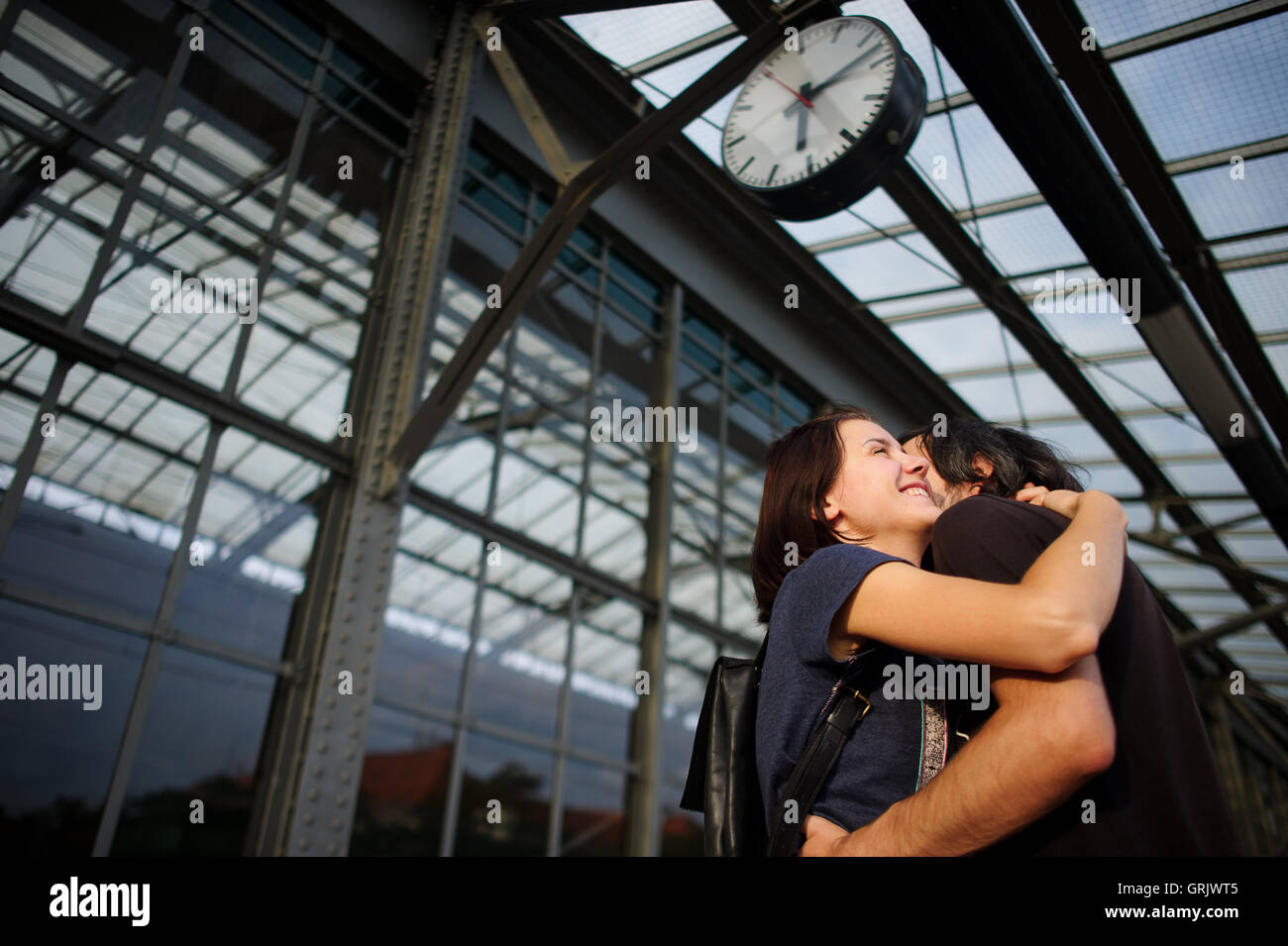Loving couple met or parted on the platform under the clock. The young