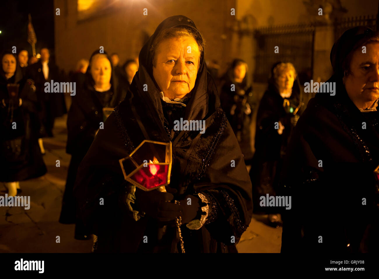 A woman dressing a mantilla holds a candle during an easter Holy Week procession in Astorga, Castilla y Leon, Spain. Stock Photo