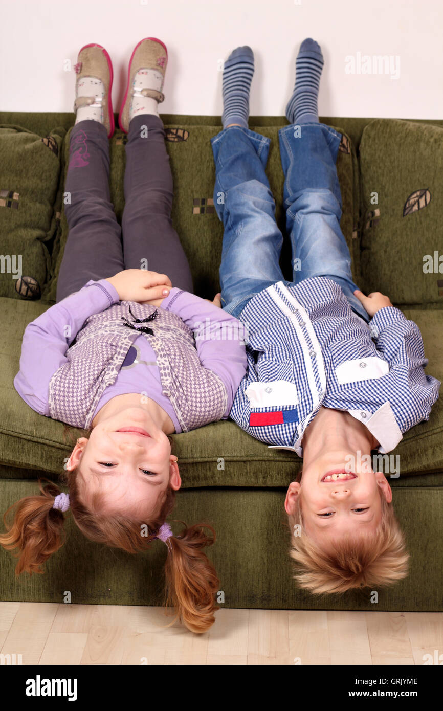 little girl and boy lying upside down on the bed Stock Photo Alamy