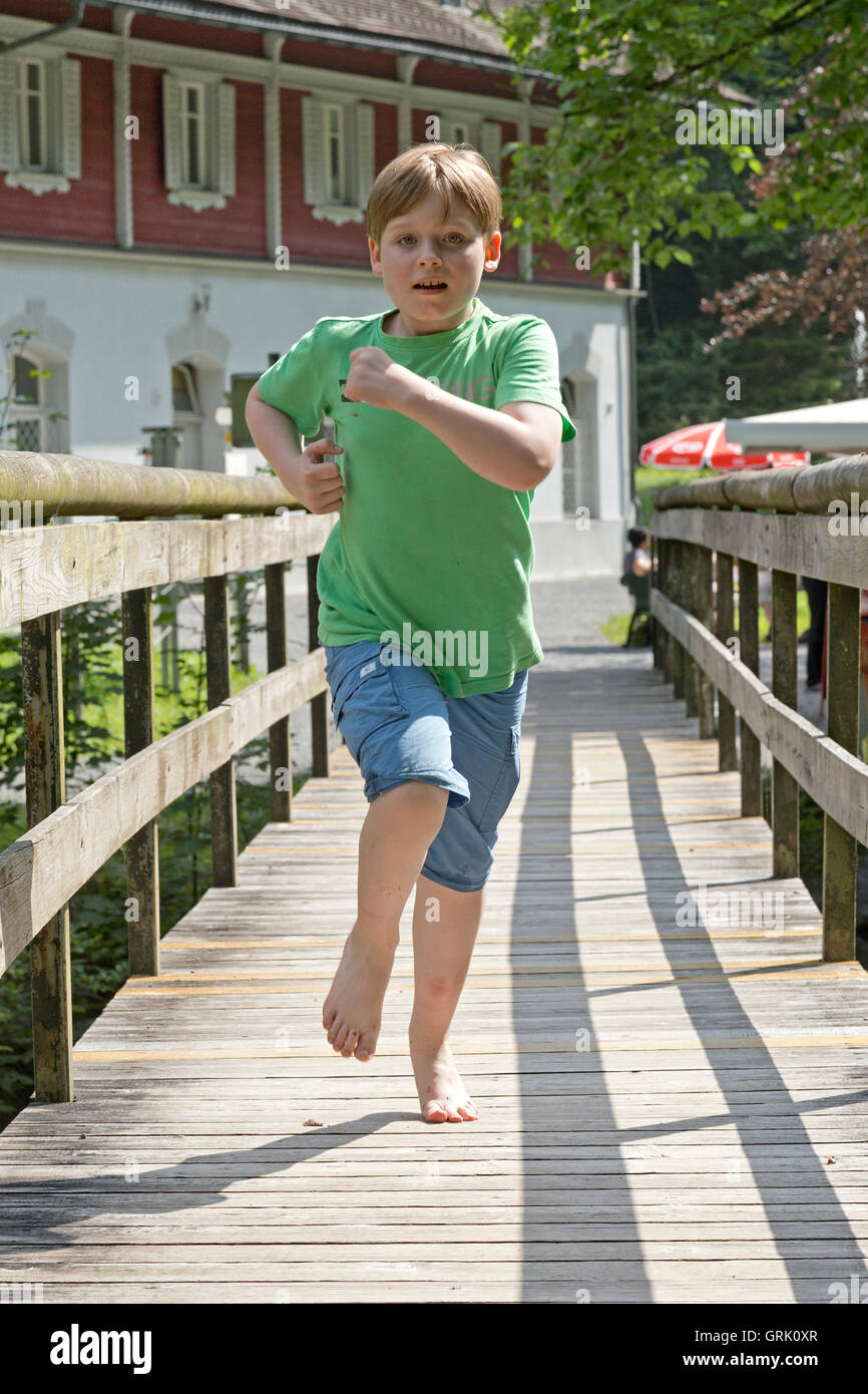young boy running across footbridge, Lake Staufen, Guetle, Dornbirn, Vorarlberg, Austria Stock Photo