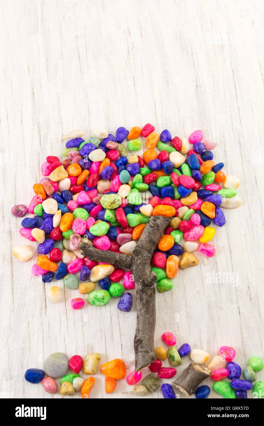 Colorful rocks forming a tree shape on wooden table Stock Photo