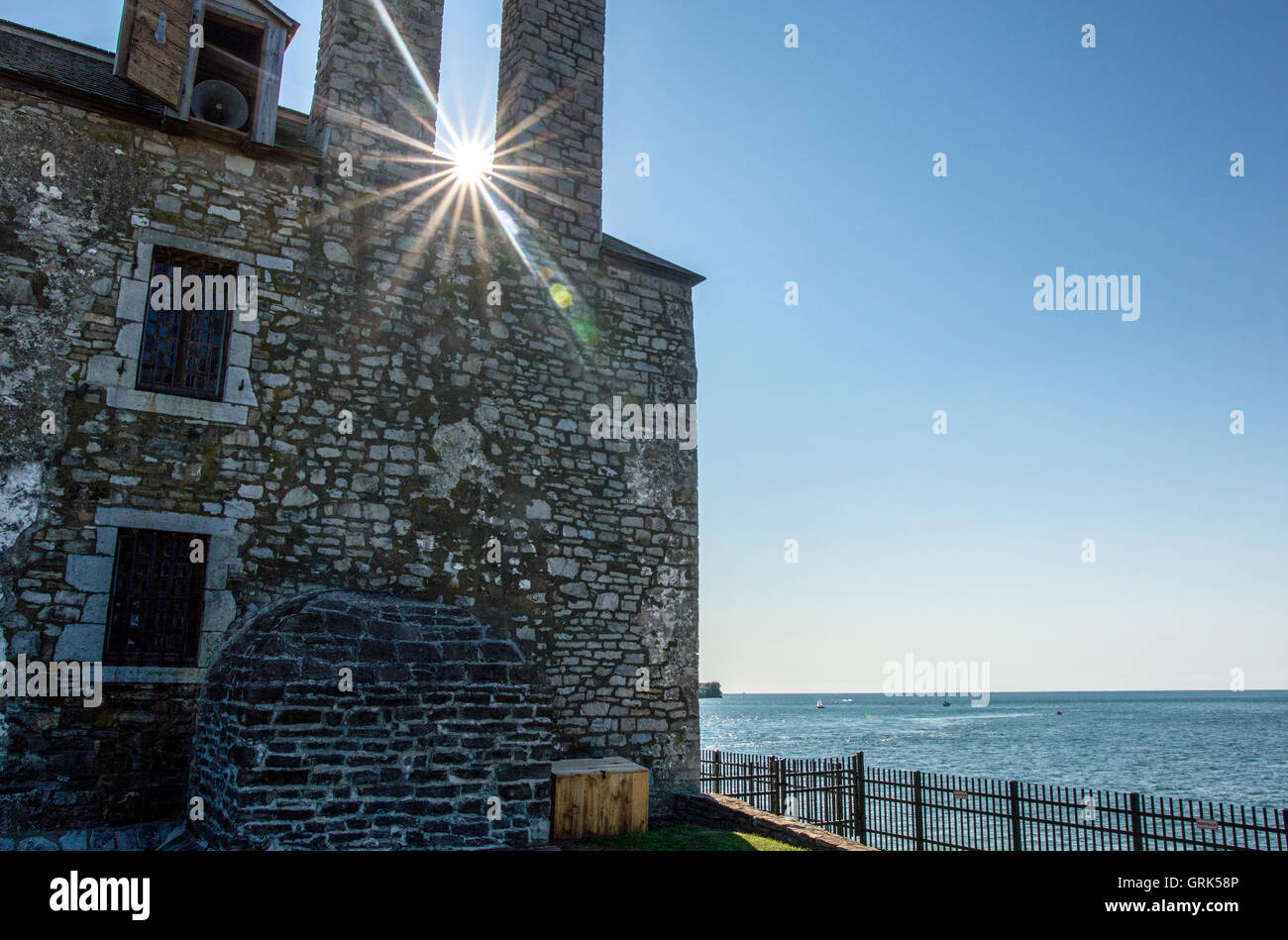 Sun flare behind the French fort at Fort Niagara, New York, on Lake Ontario at sunset. Stock Photo