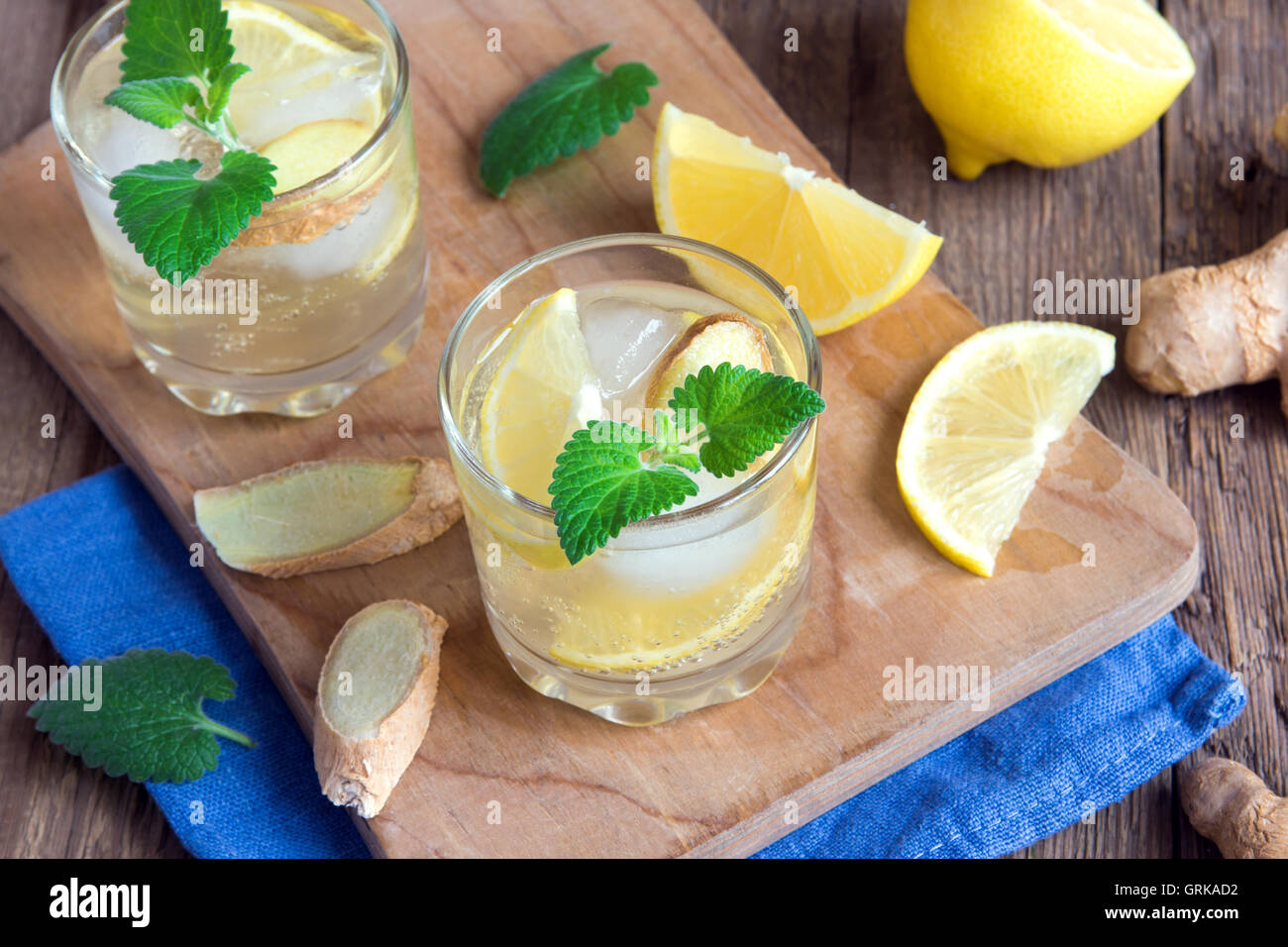 Ginger ale soda with lemon, mint, ginger and ice over rustic wooden
