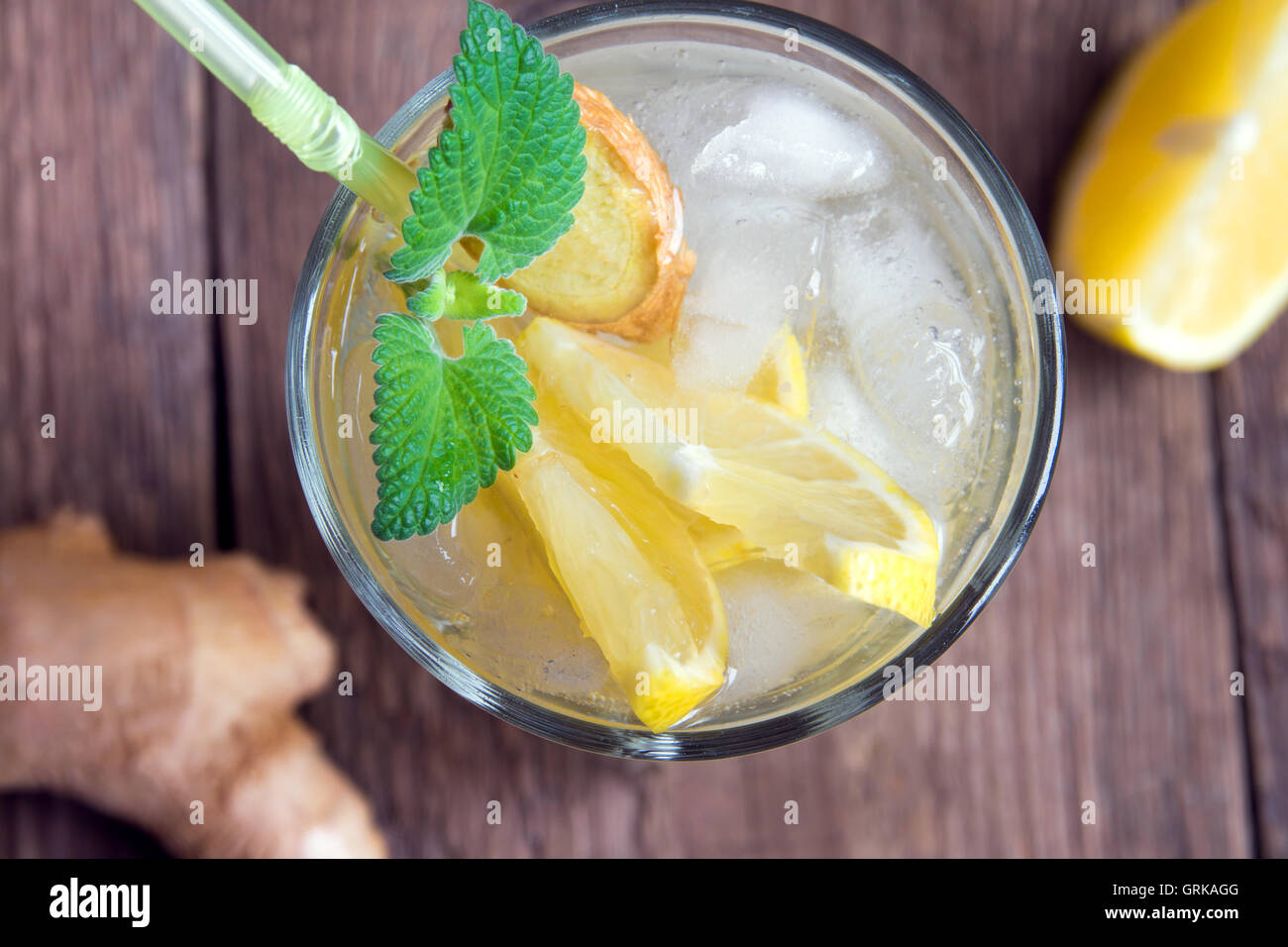 Ginger ale soda with lemon, mint, ginger and ice over rustic wooden