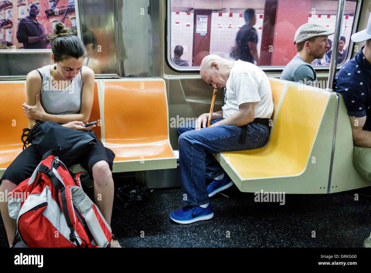 New York City,NY NYC,subway,MTA,public transportation,train,interior inside,sitting seated,stopped,adult adults,woman women female lady,man men male,s Stock Photo